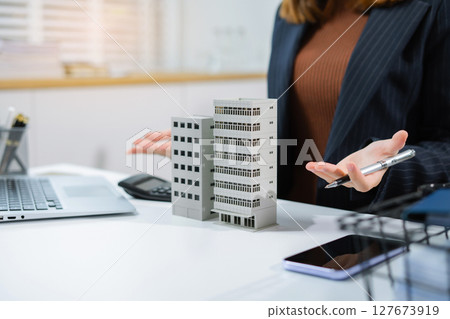 Home loan officer holding model home loan concept. 127673919