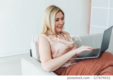 woman working on laptop negotiation online on sofa at home 127674032