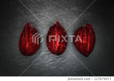 Abstract composition of three pieces beetroot placed in line on black stone background surface 127674071
