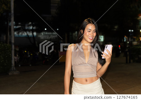 Asian Woman Using Smartphone at Night in City 127674165