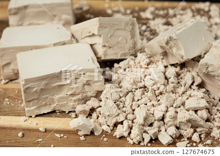 Compressed fresh yeast cubes close-up on a wooden background. 127674675