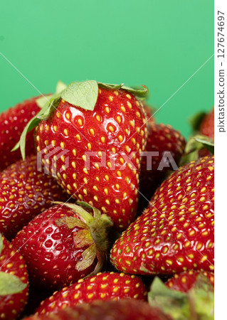 Pile of fresh ripe strawberries on a green background Pile of fresh ripe strawberries on a green background 127674697