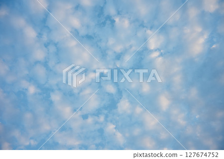 Beautiful blue sky dotted with small white clouds forming a relaxing and peaceful pattern Beautiful blue sky dotted with small white clouds forming a relaxing and peaceful pattern 127674752