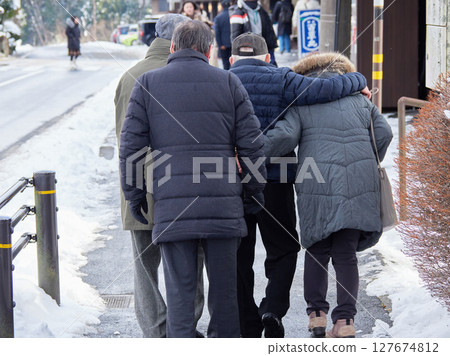 在雪景旅遊勝地散步的老年男女遊客 127674812