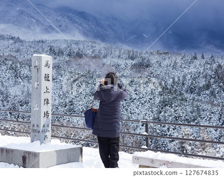 Snow scenery and tourists at the observation deck of Magome-juku, a tourist spot on the Nakasendo road 127674835