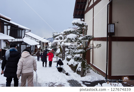 Snow-covered old townscape and tourists at Magome-juku, a tourist spot on the Nakasendo road in winter 127674839