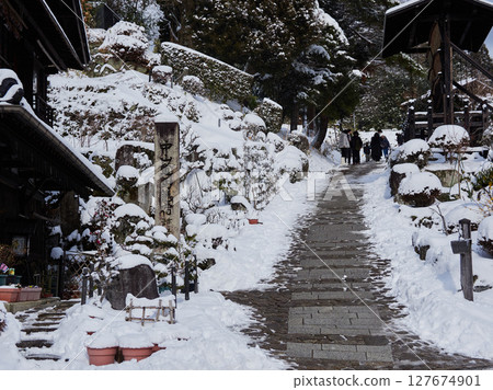 Snow-covered old townscape and tourists at Magome-juku, a tourist spot on the Nakasendo road in winter Snow-covered old townscape and tourists at Magome-juku, a tourist spot on the Nakasendo road in winter 127674901