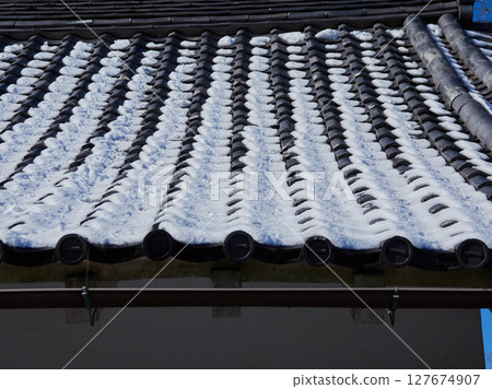 Roof tiles and snow on a traditional Japanese house in winter 127674907