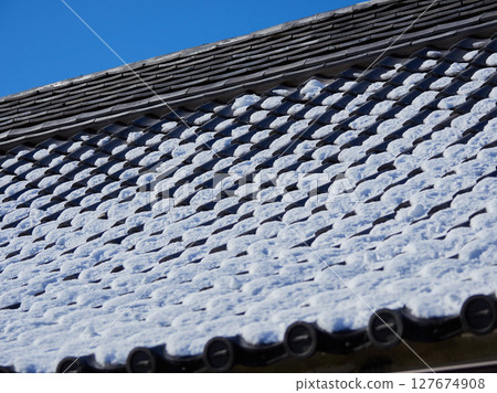 Roof tiles and snow on a traditional Japanese house in winter 127674908