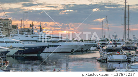 Morning view with rising sun in clouds on Harbor with yachts in parking lots in district Monte Carlo Morning view with rising sun in clouds on Harbor with yachts in parking lots in district Monte Carlo 127675237