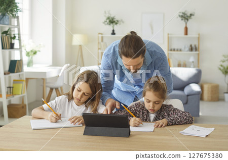 Father looking after children while they are having remote class or doing homework Father looking after children while they are having remote class or doing homework 127675380