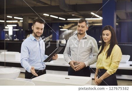 Sale manager consulting couple customers in show room, marketing, showing clients modern sink Sale manager consulting couple customers in show room, marketing, showing clients modern sink 127675382