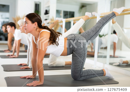 Young woman doing pilates in gym 127675409