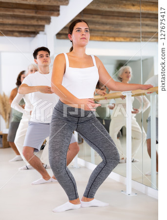 Young woman doing choreography at ballet barre Young woman doing choreography at ballet barre 127675417