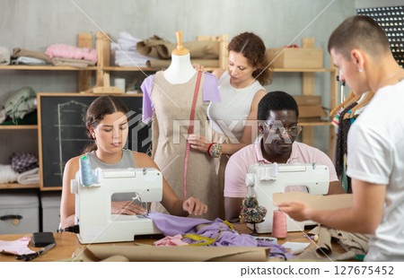 Focused attendees of dressmaking courses engaged in different activities 127675452