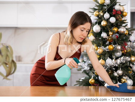 Young woman wipes the table with a damp cloth Young woman wipes the table with a damp cloth 127675467