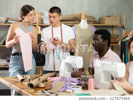Two students working with textile and others sewing Two students working with textile and others sewing 127675468