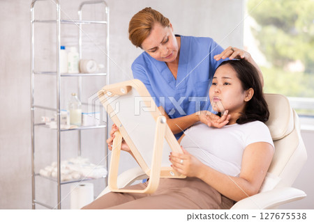 Female doctor giving consultation about injection for lips to female patient in aesthetic clinic 127675538