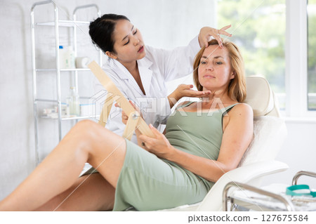 Asian doctor consulting elderly woman about procedures Asian doctor consulting elderly woman about procedures 127675584