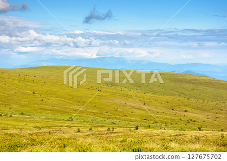 mountain landscape with green grass in summer. alpine meadow under blue sky with clouds. beautiful nature scenery with distant ridge. vast land mountain landscape with green grass in summer. alpine meadow under blue sky with clouds. beautiful nature scenery with distant ridge. vast land 127675702