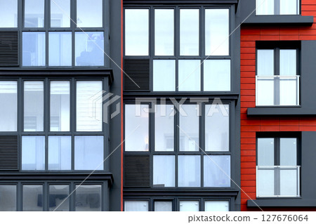 Closeup of modern apartment building with red glass windows and geometric facade. Contemporary urban 127676064