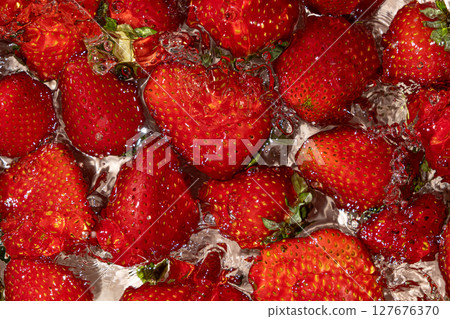 Whole Strawberry Dropped into Water. Splash Effect and Vibrant Summer Look. Whole Strawberry Dropped into Water. Splash Effect and Vibrant Summer Look. 127676370