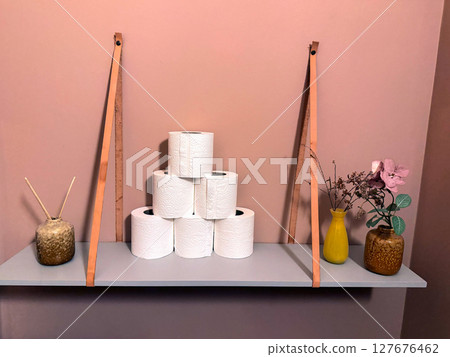 Toilet paper shelf with artificial flowers and incense sticks 127676462