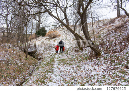 Exploring a winter wonderland with loved ones on a snowy day in a peaceful outdoor setting surrounded by trees and gentle slopes Exploring a winter wonderland with loved ones on a snowy day in a peaceful outdoor setting surrounded by trees and gentle slopes 127676625