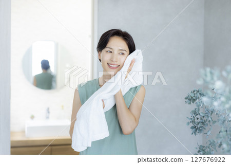 一位女士洗臉並用毛巾擦乾 一位女士洗臉並用毛巾擦乾 127676922