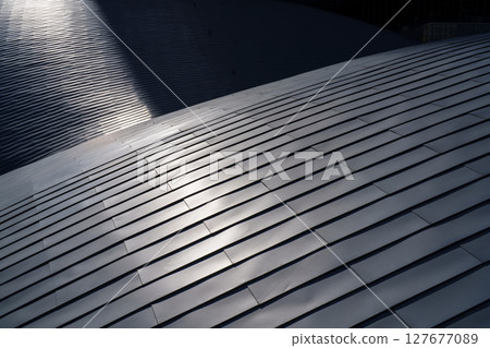 Oblique light and geometric patterns shining on the metal roof Oblique light and geometric patterns shining on the metal roof 127677089