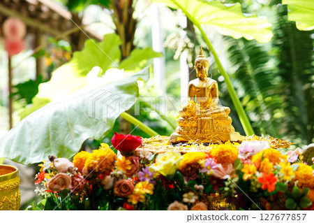 Buddha image and flowers. Preparation for Water Festival in Thailand. 127677857