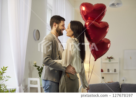 Portrait of a young attractive happy smiling woman and man looking at each other and hugging 127678197