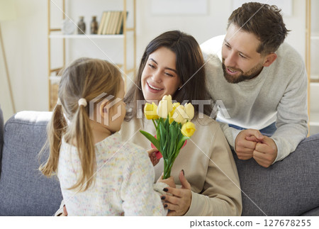 Cute small daughter, child girl and loving young mother, father congratulating 127678255