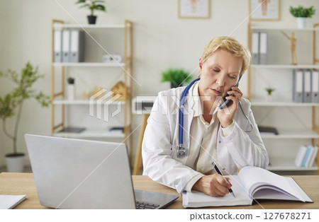 Elderly Doctor Working Online With Laptop In Hospital Office 127678271