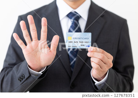 一位西裝革履的商人,手裡拿著信用卡,伸出五根手指 一位西裝革履的商人,手裡拿著信用卡,伸出五根手指 127678351