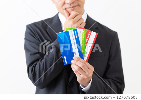 A middle-aged male businessman in a suit worried about his bank deposit book 127678603