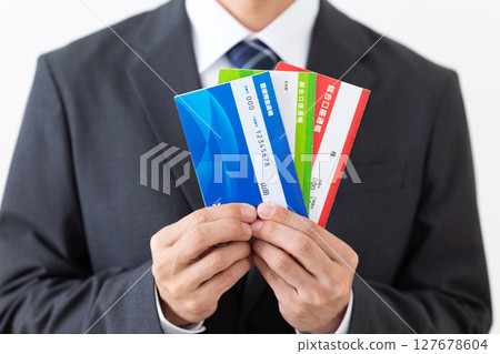 A middle-aged male businessman wearing a suit holding a bank deposit book 127678604