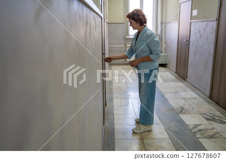 Woman opening the door to her office at the start of the workday. Entry, new beginning, and everyday professional routine. Woman opening the door to her office at the start of the workday. Entry, new beginning, and everyday professional routine. 127678607