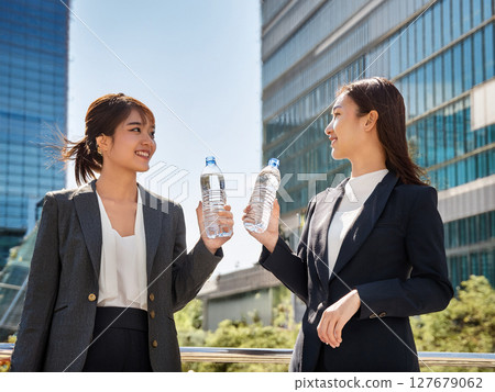 A woman drinking water in an office district 127679062