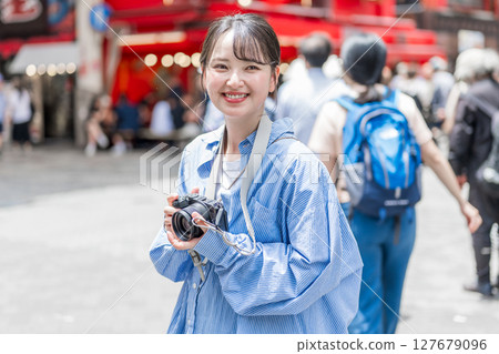 Young and cute woman enjoying her hobby of photography in Osaka's entertainment district | Photo taken in Osaka Prefecture 127679096