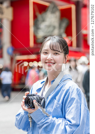 Young and cute woman enjoying her hobby of photography in Osaka's entertainment district | Photo taken in Osaka Prefecture 127679102