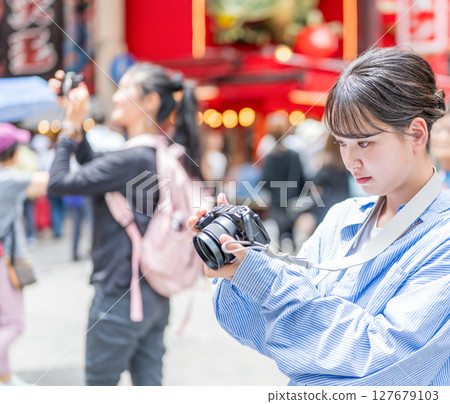 Young and cute woman enjoying her hobby of photography in Osaka's entertainment district | Photo taken in Osaka Prefecture 127679103