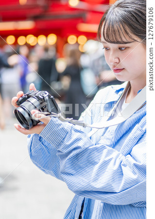 Young and cute woman enjoying her hobby of photography in Osaka's entertainment district | Photo taken in Osaka Prefecture 127679106