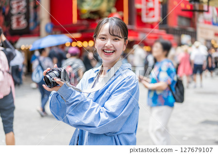 Young and cute woman enjoying her hobby of photography in Osaka's entertainment district | Photo taken in Osaka Prefecture 127679107