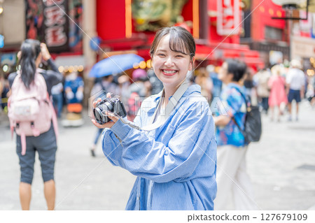 Young and cute woman enjoying her hobby of photography in Osaka's entertainment district | Photo taken in Osaka Prefecture 127679109