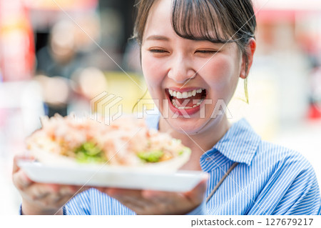 大阪府大阪市道頓堀,一名女子在戶外吃章魚燒 大阪府大阪市道頓堀,一名女子在戶外吃章魚燒 127679217