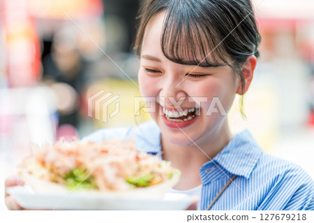 大阪府大阪市道頓堀,一名女子在戶外吃章魚燒 大阪府大阪市道頓堀,一名女子在戶外吃章魚燒 127679218