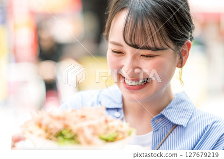 大阪府大阪市道頓堀,一名女子在戶外吃章魚燒 大阪府大阪市道頓堀,一名女子在戶外吃章魚燒 127679219