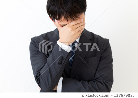 一位身著西裝、遮住臉、憂心忡忡的中年男性商人 127679853