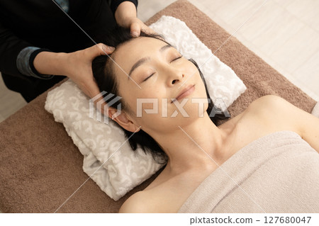 接受頭部按摩治療的婦女 接受頭部按摩治療的婦女 127680047